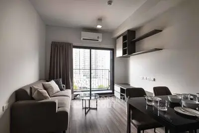 Modern living room with sleek furniture and large window offering city view