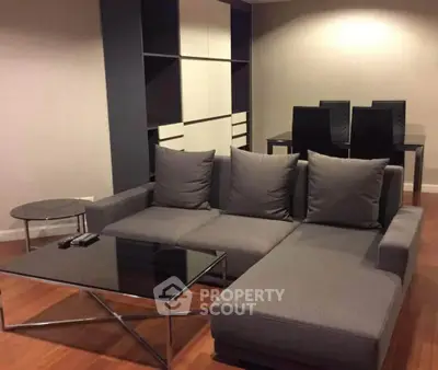 Modern living room with sleek gray sofa and stylish glass tables