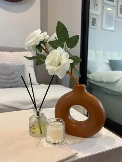 Stylish living room with modern decor and cozy ambiance, featuring elegant floral arrangement and scented candle.