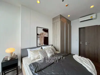 Modern bedroom with stylish decor and cozy ambiance, featuring a comfortable bed and elegant lighting.