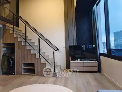 Modern duplex living room with stylish staircase and large windows offering city views.