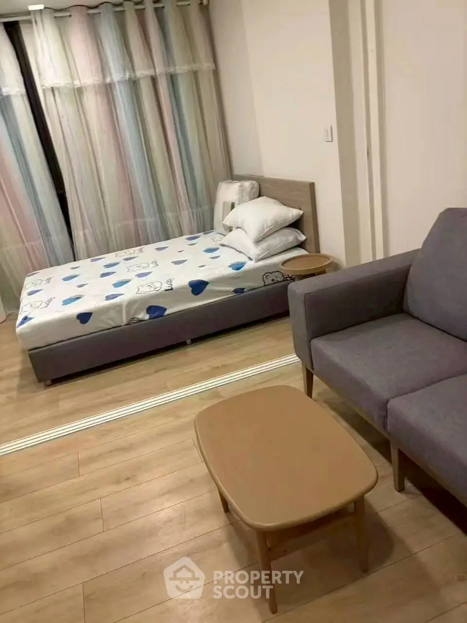 Cozy bedroom with modern furniture and wooden flooring, perfect for relaxation.