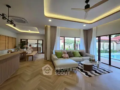 Spacious modern living room with pool view, featuring elegant decor and open layout for luxurious living.