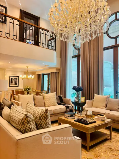 Luxurious living room with high ceilings, elegant chandelier, and plush seating in a sophisticated setting.