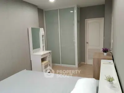Modern bedroom with sleek wardrobe and vanity in a stylish apartment.