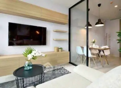 Modern living room with sleek design and open dining area, featuring stylish furniture and decor.