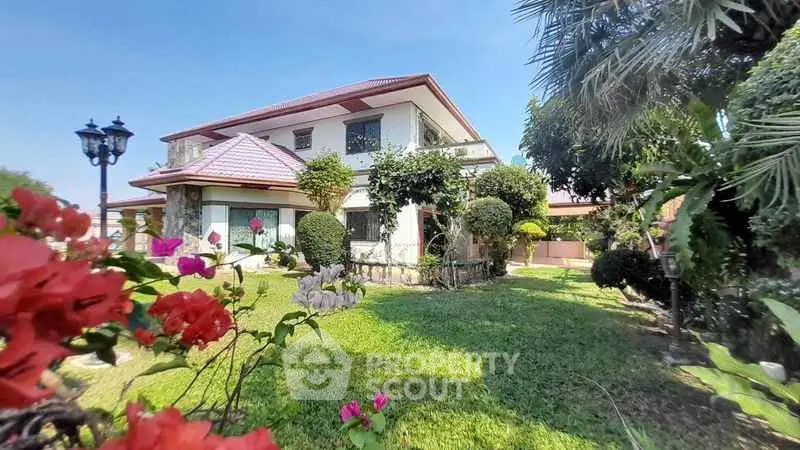 Charming two-story house with lush garden and vibrant flowers