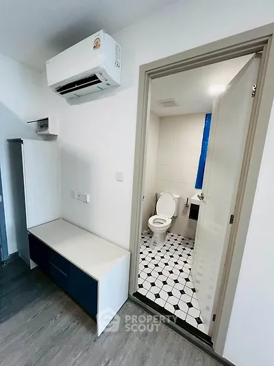 Modern apartment with air conditioning and stylish bathroom featuring geometric floor tiles.