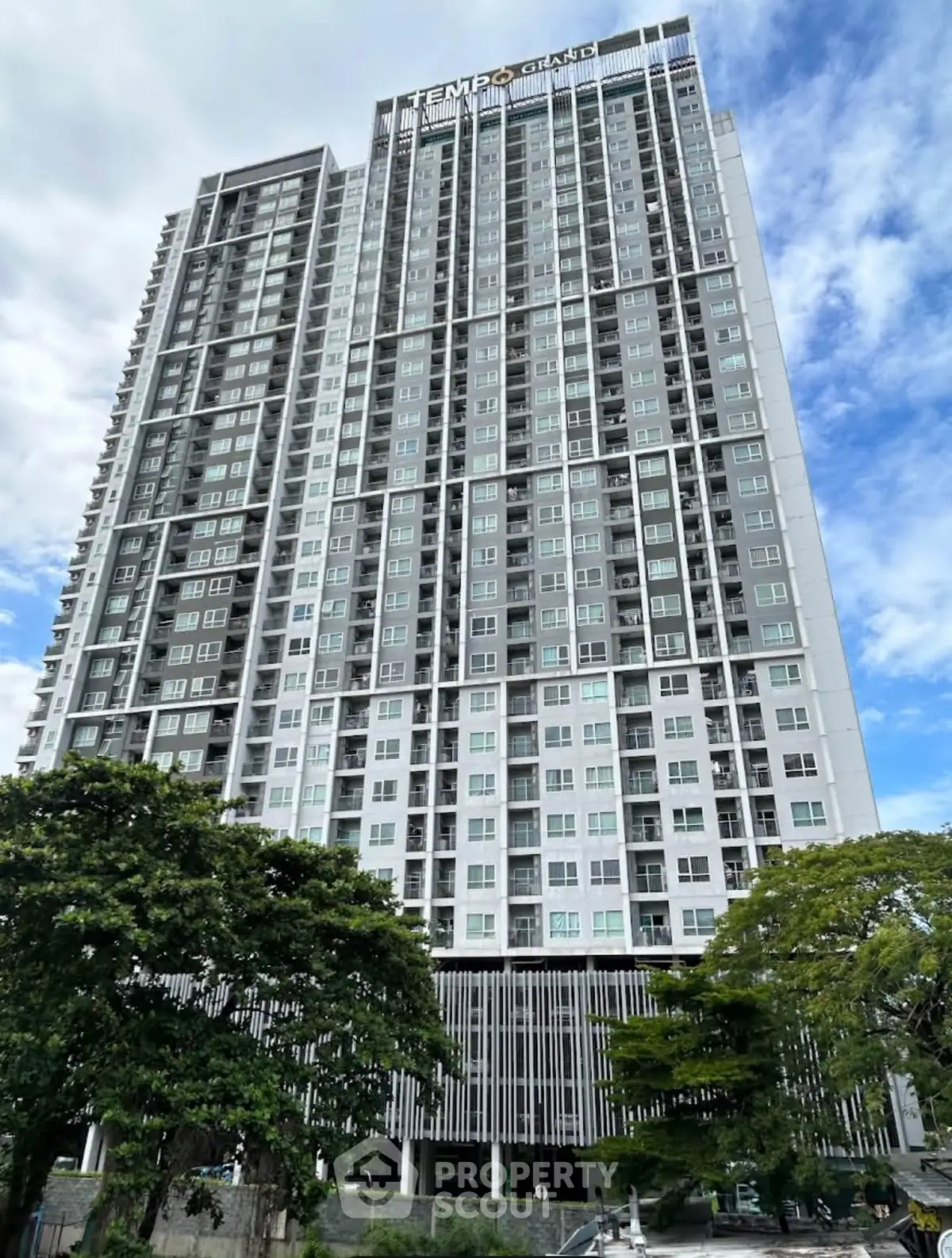 Stunning high-rise building with modern architecture and lush greenery, perfect for urban living.
