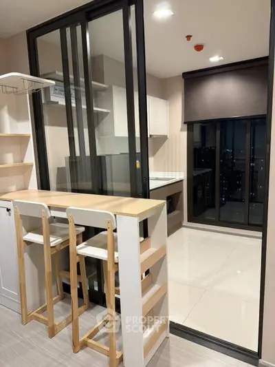 Modern kitchen with open layout and sleek design, featuring a breakfast bar and large windows for natural light.