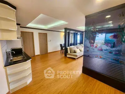 Spacious open-plan living room with modern decor and unique aquarium feature wall.