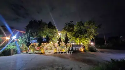 Charming night view of a well-lit garden entrance with lush greenery.