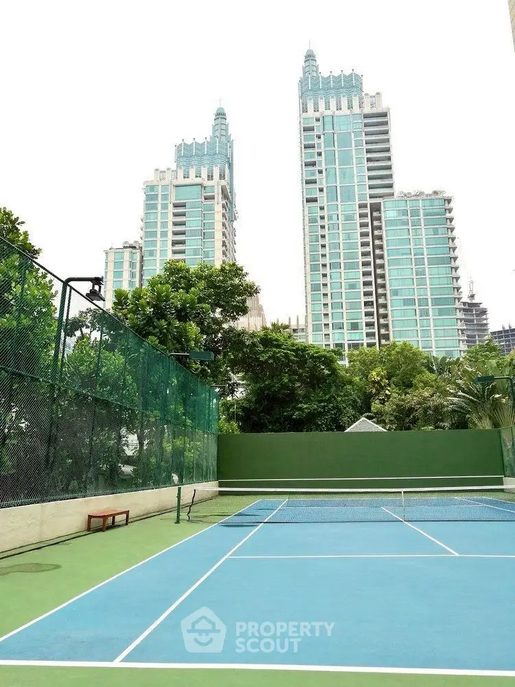 Luxurious high-rise buildings with tennis court and lush greenery in a prime urban location.