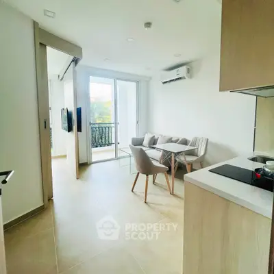 Modern open-plan living room with balcony and sleek kitchen design