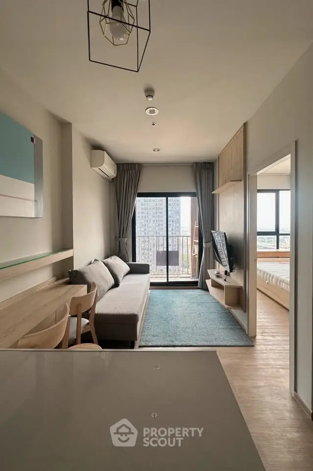 Modern living room with stylish decor and large windows offering a stunning city view.