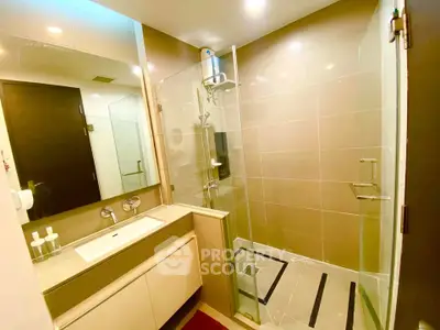 Modern bathroom with glass shower and sleek vanity in luxury apartment