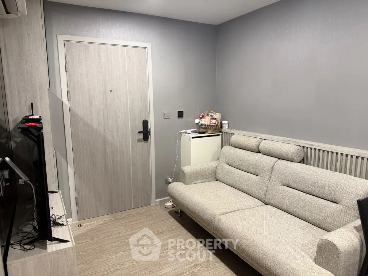 Cozy living room with modern sofa and entertainment setup, perfect for relaxation.