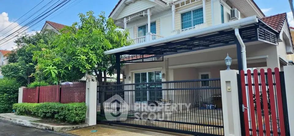 Charming suburban house with gated driveway and lush greenery, perfect for family living.