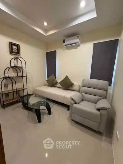 Cozy living room with modern furniture and air conditioning, perfect for relaxation.