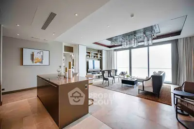 Luxurious open-plan living room with modern decor and stunning floor-to-ceiling windows.