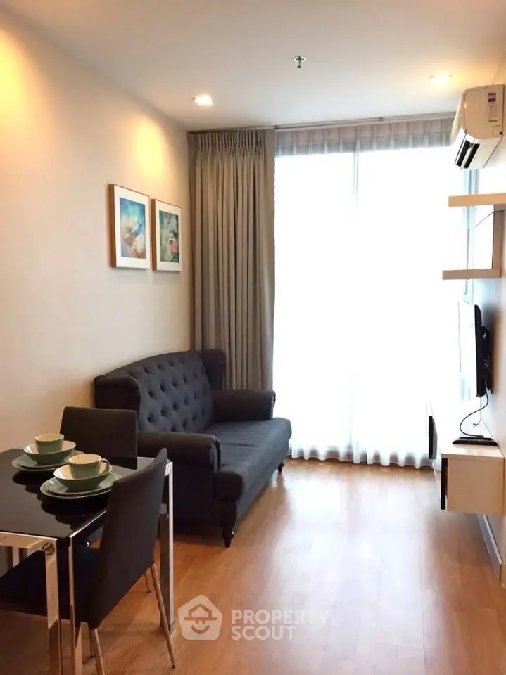 Modern living room with elegant decor, featuring a cozy sofa, dining set, and wall-mounted TV in a bright space.
