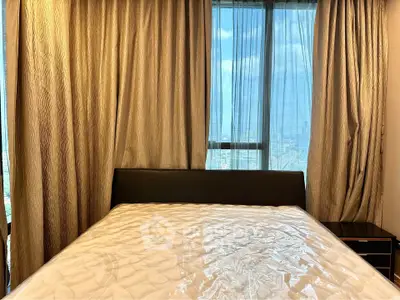 Luxurious bedroom with large window offering stunning city views and elegant curtains.