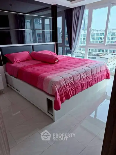 Modern bedroom with large windows and pink bedding in a high-rise apartment.
