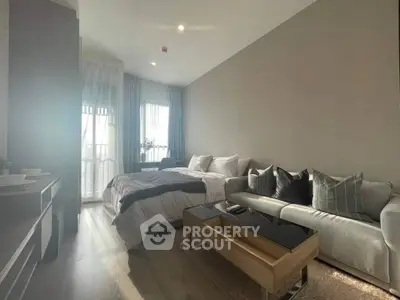 Modern bedroom with cozy living area and natural light, perfect for urban living.