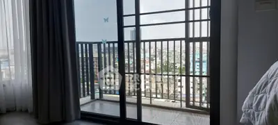 Spacious apartment with balcony offering stunning city views through large sliding glass doors.