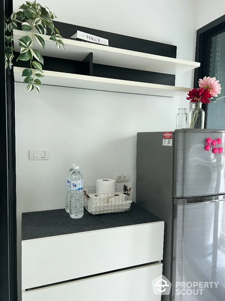 Modern kitchen corner with sleek fridge and stylish shelving