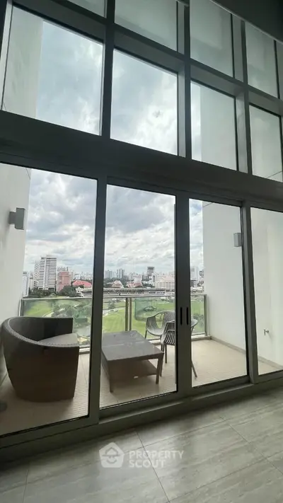 Luxurious high-rise apartment with floor-to-ceiling windows offering panoramic city views and a cozy balcony retreat with modern furnishings.