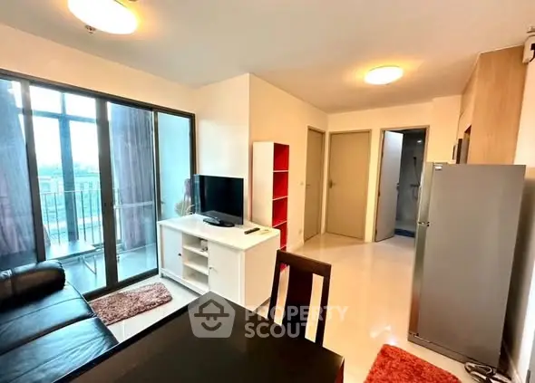 Modern living room with balcony access and sleek furnishings in a stylish apartment.