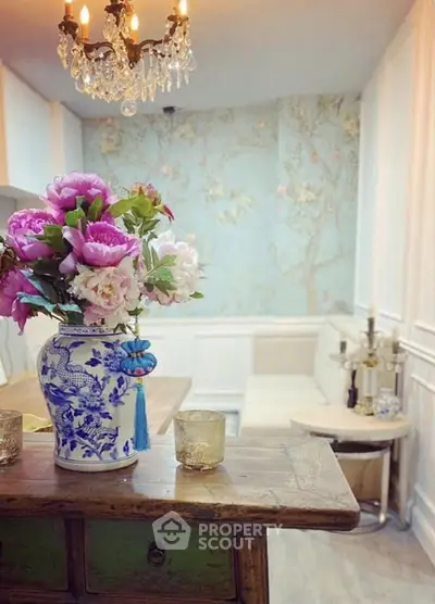 Charming living room with elegant chandelier and floral decor, perfect for cozy gatherings.