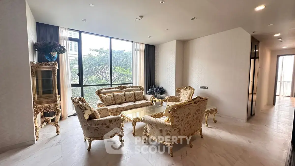 Luxurious living room with elegant furniture and large windows offering a serene view of greenery.