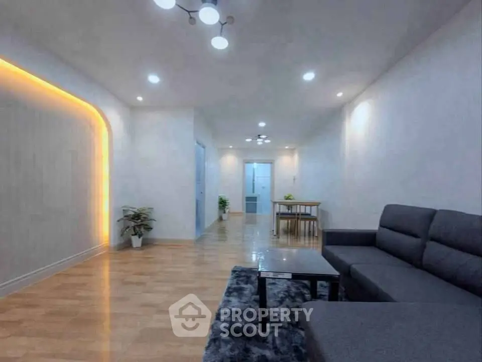 Spacious modern living room with stylish lighting and cozy seating area.