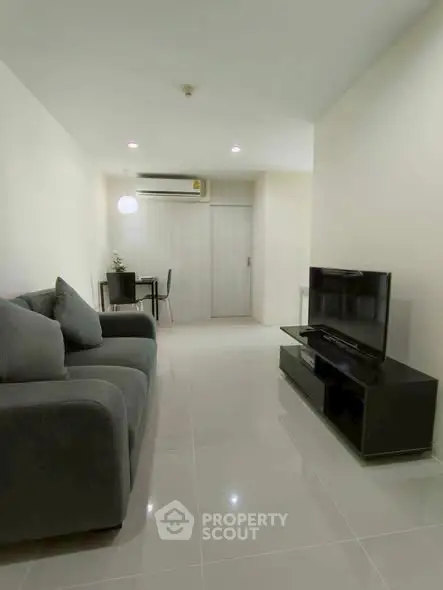 Modern living room with sleek furniture and minimalist design, featuring a comfortable sofa and flat-screen TV.