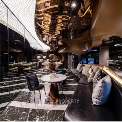 Luxurious modern interior with sleek black and gold design, plush seating, and elegant lighting.