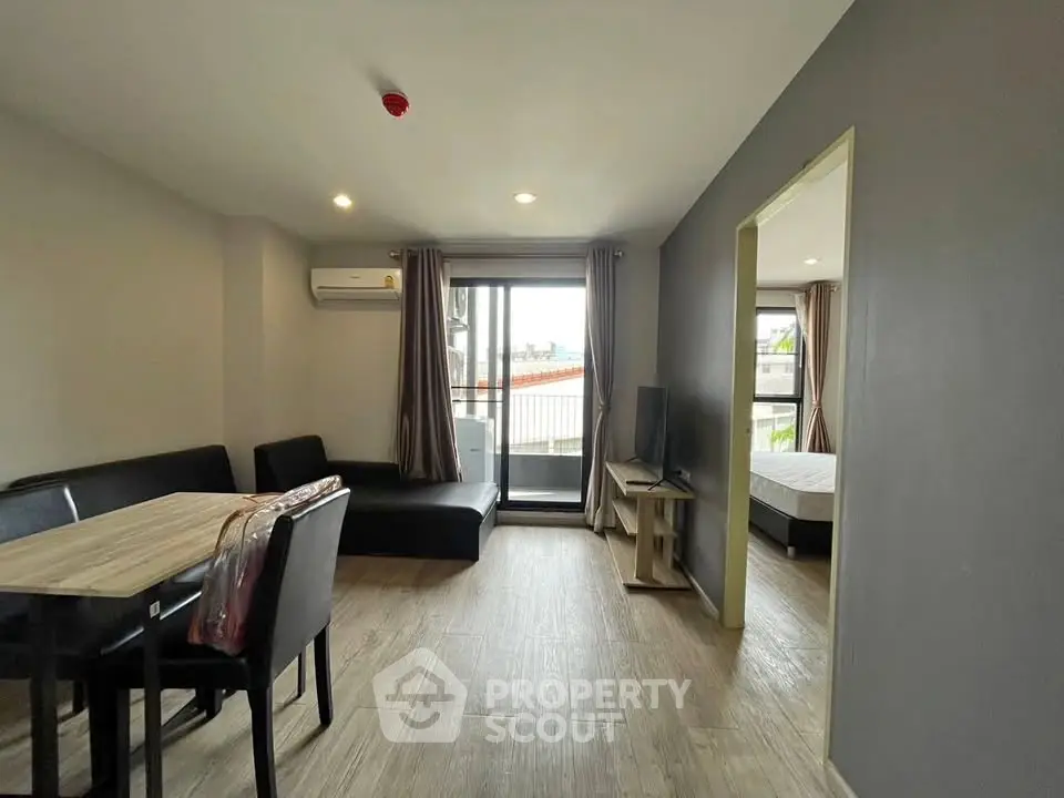Modern living room with dining area and balcony access in stylish apartment.