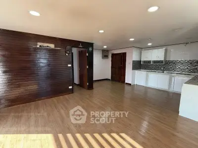 Spacious open-plan living area with modern kitchen and wooden flooring