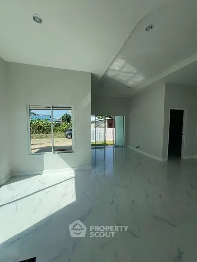 Spacious modern living room with large windows and glossy tile flooring