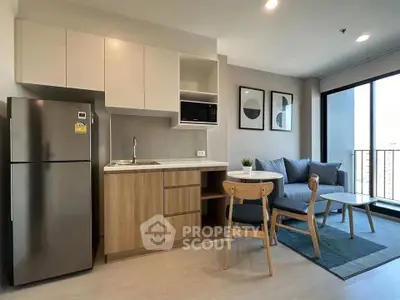 Modern open-layout kitchen and living room with stylish decor and natural light.