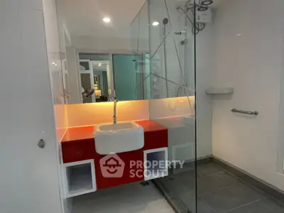 Modern bathroom with glass shower and stylish red vanity
