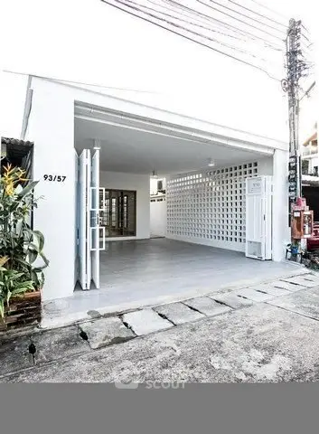 Modern minimalist garage with open design and white lattice wall in urban setting.
