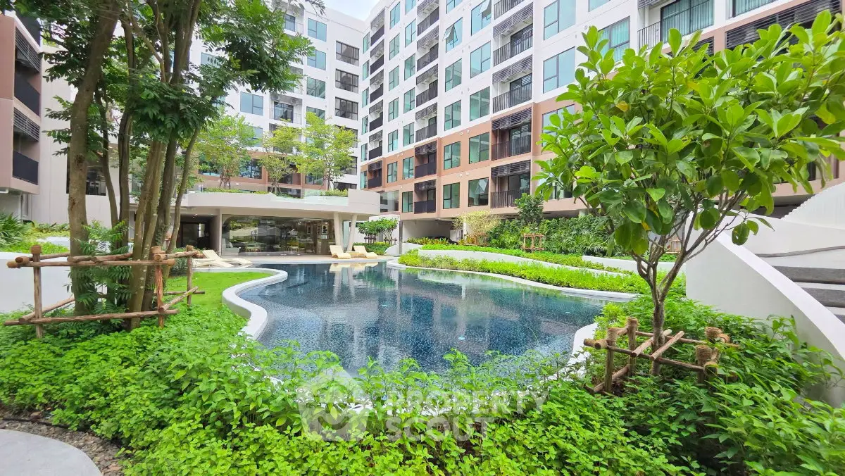Modern apartment complex with lush garden and inviting pool area, perfect for relaxation and leisure.