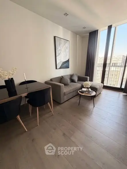 Modern living room with elegant decor and large windows offering city views.