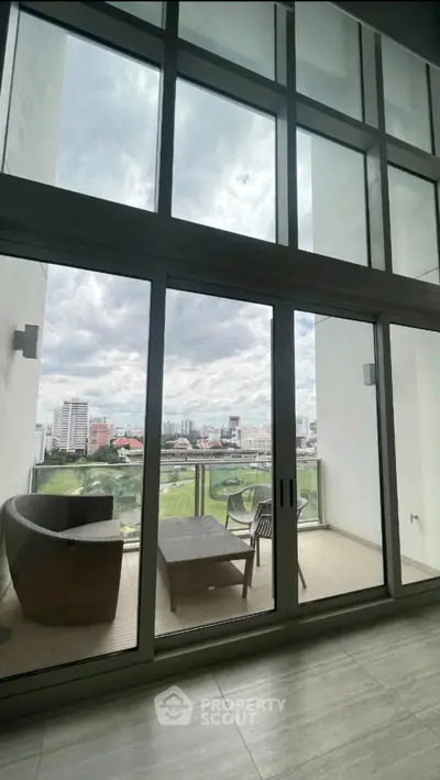 Spacious balcony with stunning city view and modern outdoor furniture.