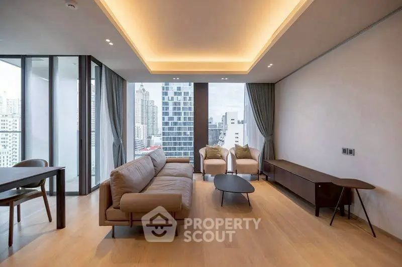 Modern living room with city view, featuring sleek furniture and large windows for natural light.