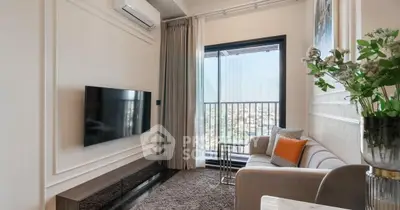 Modern living room with balcony view, featuring sleek TV setup and stylish decor.