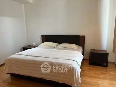 Spacious bedroom with wooden flooring and modern furniture, featuring a comfortable double bed and nightstands.