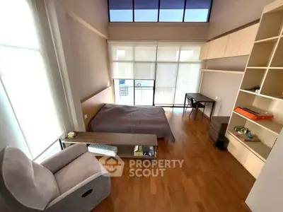 Spacious bedroom with modern design and ample natural light, featuring hardwood floors and stylish furnishings.